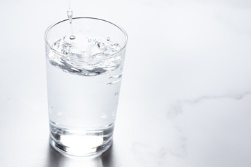 水をグラスに注ぐ。水分補給。健康・スポーツやトレーニング。