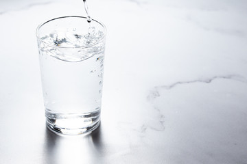 水をグラスに注ぐ。水分補給。健康・スポーツやトレーニング。