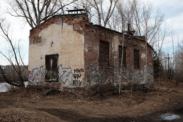 Abandoned brick building by the river. Graffiti and devastation.