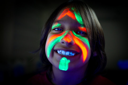 Little boy with fluorescent paint glowing portrait