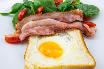 Egg in a hole bread and bacon with salad