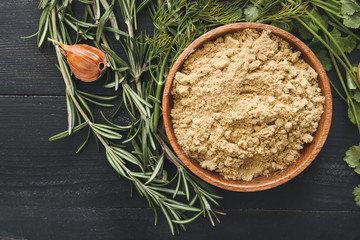 Plate with spices on dark wooden background