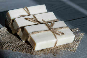 Soap packed with jute rope. Wooden background.Sunlight and shadow.