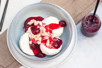 Cottage cheese pancakes with cherry sauce and nuts in grey bowl. Close up. Healthy breakfast concept.