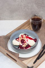 Cottage cheese pancakes with cherry sauce and nuts in grey bowl. Close up. Healthy breakfast concept.