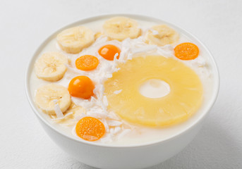 Healthy bowl of a cocktail of pineapple, coconut, bananas and Physalis. 