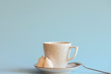 A cup of coffee latte or americano in a white cup isolated on light pastel blue background.