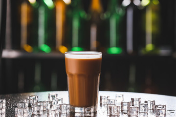 Glass with iced coffee on dark background