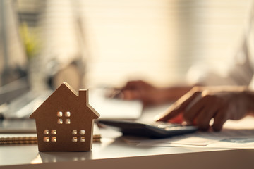 Hand of Business people calculating interest, taxes and profits to invest in real estate and home buying