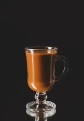 Glass cup with iced coffee on dark background