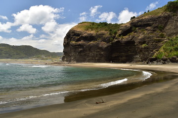 Remote wild beach with high cliffs and wild sea waves
