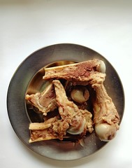 Several pieces of pork bone on a plate on a white background