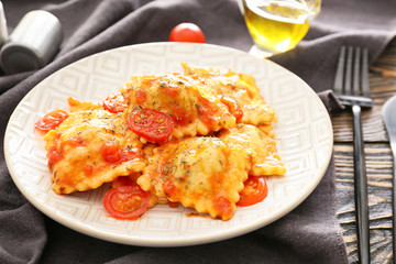Plate with tasty ravioli on table