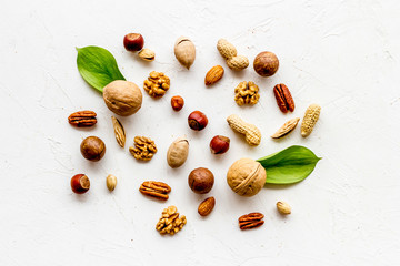 Nuts background - with almond, macadamia, walnut, hazelnut, pecans - on white table top-down