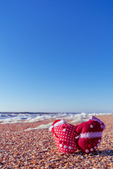 Image of soft toys in the form of mittens on the beach. Handwork.