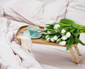 Romantic morning.A coffee table in a pink bed, a Cup of coffee and flowers on the table. Valentine's day