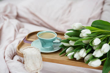 Fototapeta na wymiar Romantic morning.A coffee table in a pink bed, a Cup of coffee and flowers on the table. Valentine's day
