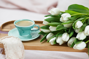 Fototapeta na wymiar Romantic morning.A coffee table in a pink bed, a Cup of coffee and flowers on the table. Valentine's day