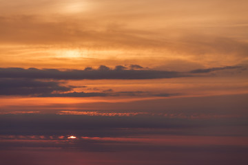 Fototapeta na wymiar The sky at sunset, with the sun, wave, orange sky, sea coast