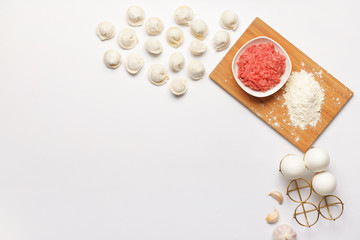 Preparing of tasty dumplings on white background