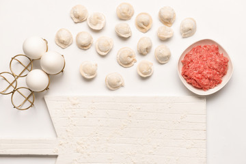 Preparing of tasty dumplings on white background