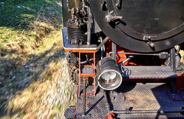 Fototapeta na wymiar Detail of a steam locomotive while driving. Dynamics through motion blur.