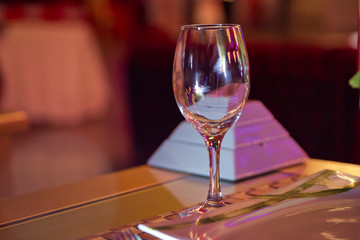 Empty wine glass. Tableware on table in cafe, focus on wineglass stem . Elegant table setting . Bakal