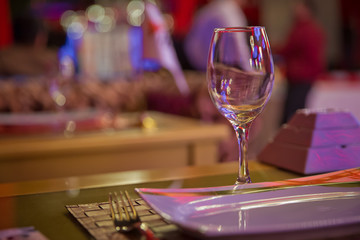 Empty wine glass. Tableware on table in cafe, focus on wineglass stem . Elegant table setting . Bakal