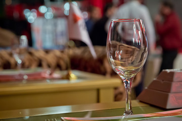 Empty wine glass. Tableware on table in cafe, focus on wineglass stem . Elegant table setting . Bakal