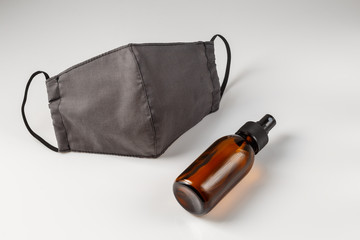 Reusable cotton mask and glass bottle of sanitizer