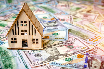 The symbol of the house stands against the background of us dollars
