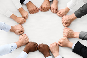 Group of business people putting hands together in office, top view. Unity concept
