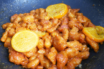 Chicken meat cut into small pieces and wrapped in egg flour mixture. Put into the hot pan. It is fried using hot cooking oil until cooked and crunchy. Added with orange as a seasoning.