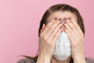 Social problems. Flu epidemic. A woman cries covering her face with her hands. Drug addiction. a woman in a medical mask hides her face with her hands in fear or frustration from coronavirus and other