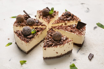 Pieces of tasty chocolate cheesecake on white background