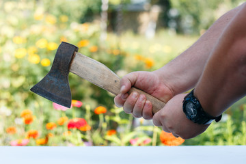 the axe in his hands. men's hands with watches hold an axe.