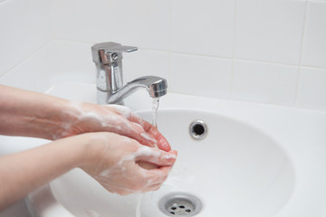 Hygiene is washing hands with soap and water over the white sink