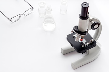 Laboratory examination with microscope. Equipment with blood sample on white background copy space