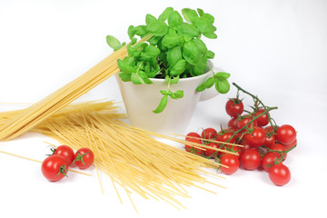 closeup of cherry tomatoes, spaghetti and basil jar on a white background	
