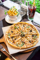 An Italian pizza with French fries