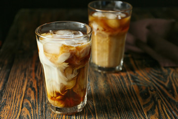 Glass of tasty iced coffee on wooden background