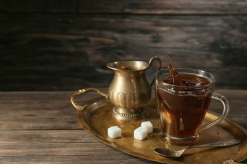 Splashing of coffee in glass cup on table
