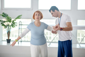 Pleasant aged woman trying to hold balance