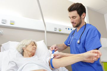 Fototapeta premium a doctor takes blood from a female senior
