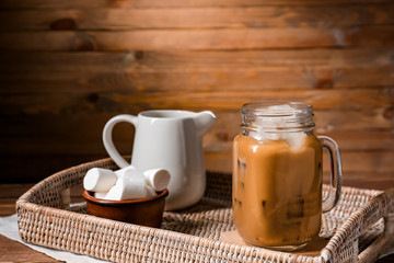 Obraz na płótnie Canvas Mason jar of tasty iced coffee with marshmallows on table