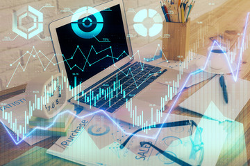 Financial graph colorful drawing and table with computer on background. Double exposure. Concept of international markets.