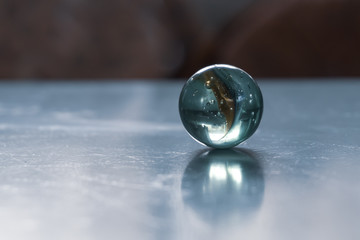 Cold toned abstract close up of crystal shpere reflecting light on ice surface