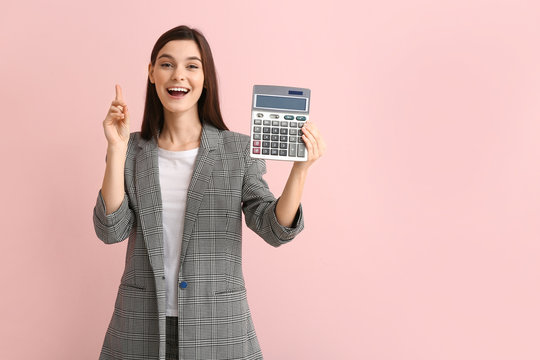 Young woman with calculator and raised index finger on color background