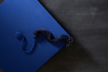 Graduation hat, diploma scroll on the blackboard