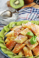 Austrian dessert Kaiserschmarrn served with sugar powder and kiwi fruit	